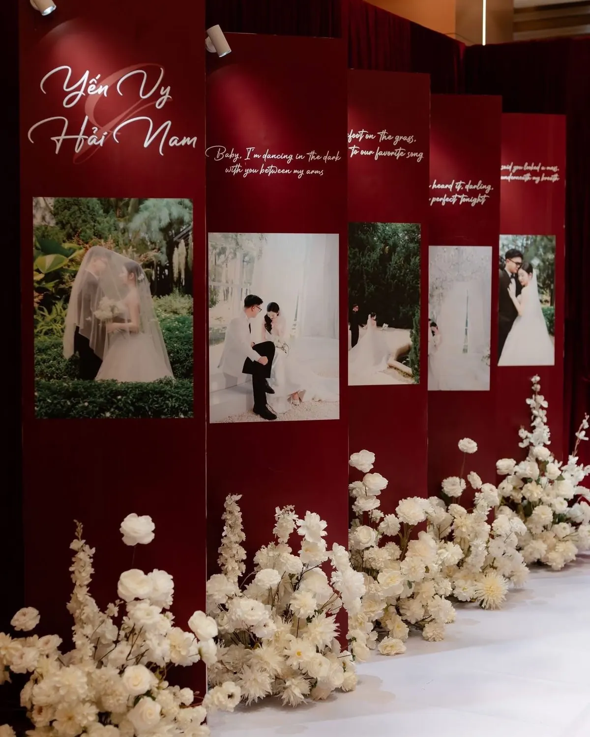 Photo wall with framed couple portraits and florals